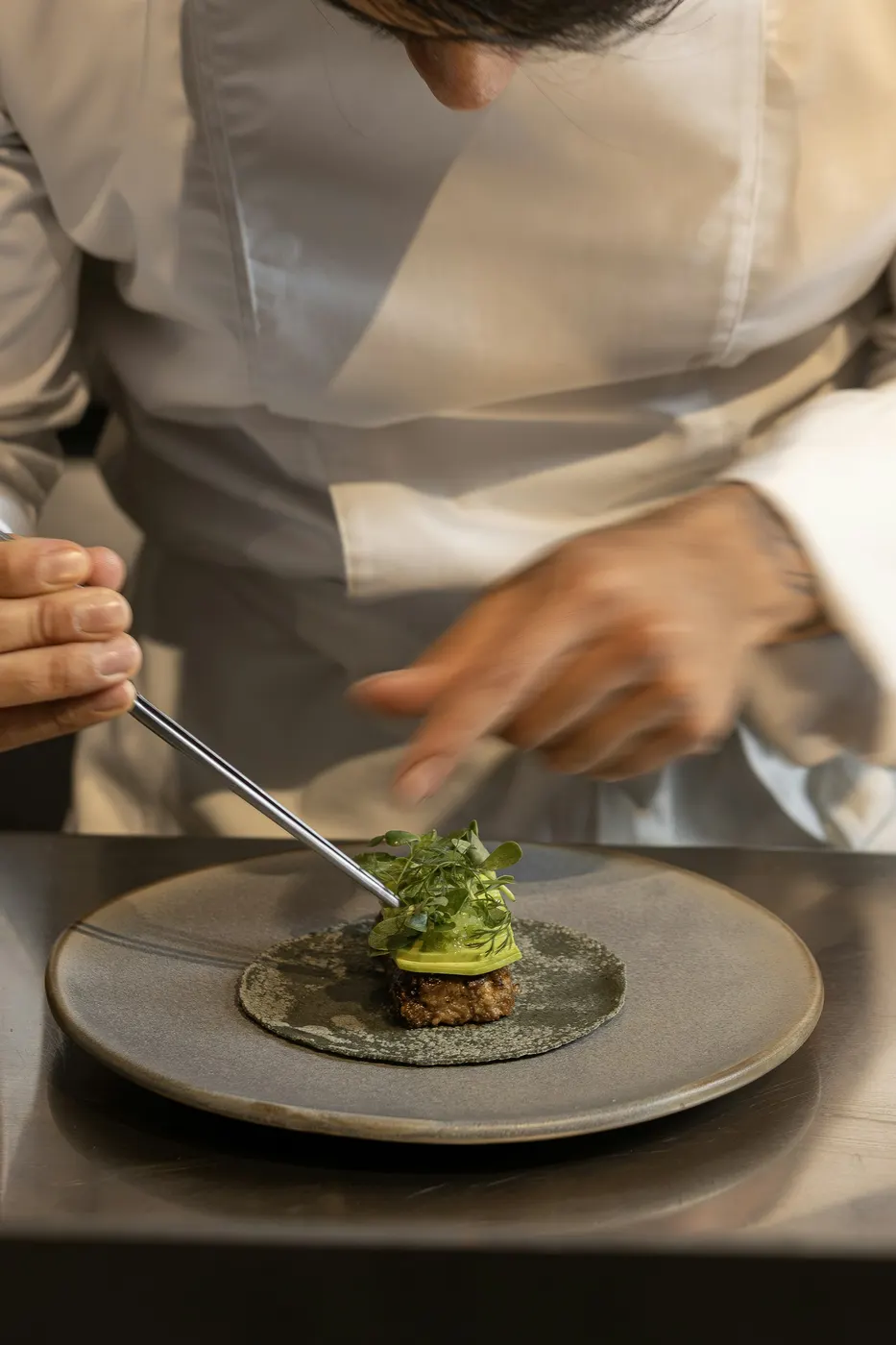 Chef carefully plating a dish in the kitchen