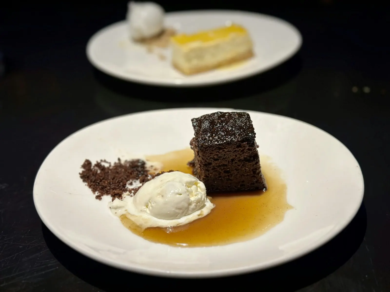 Dark sponge pudding served with ice cream and sauce