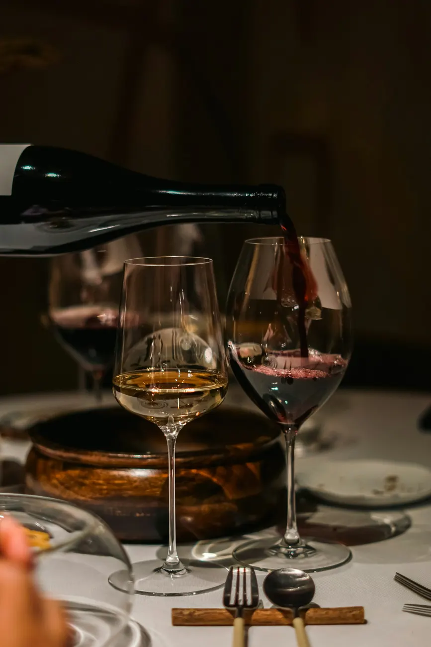 Wine being poured into a glass at a restaurant table